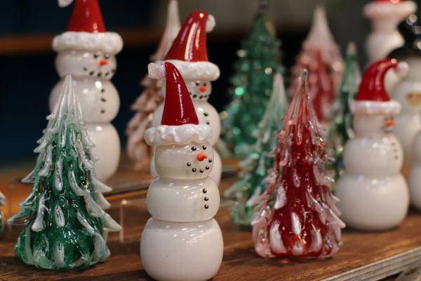 Glass-blown snowmen with santa hats and red and green trees