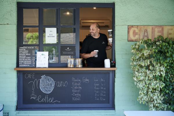 Man serves coffee from a cafe in Subiaco Perth City