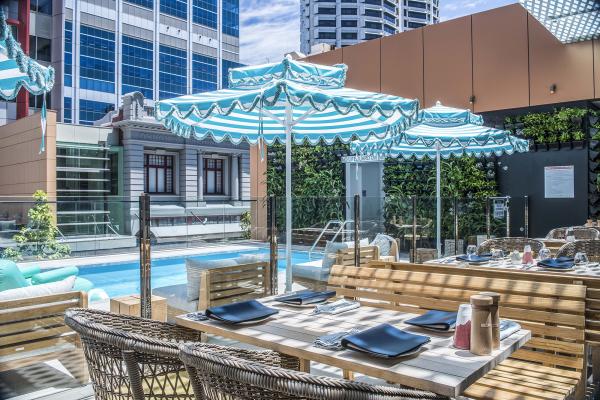 View of a set dining table beside the pool area at BAHA Poolside Bar & Kitchen.