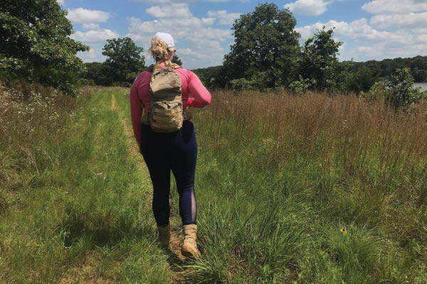 A woman with a backpack hiking at Lake McMurtry