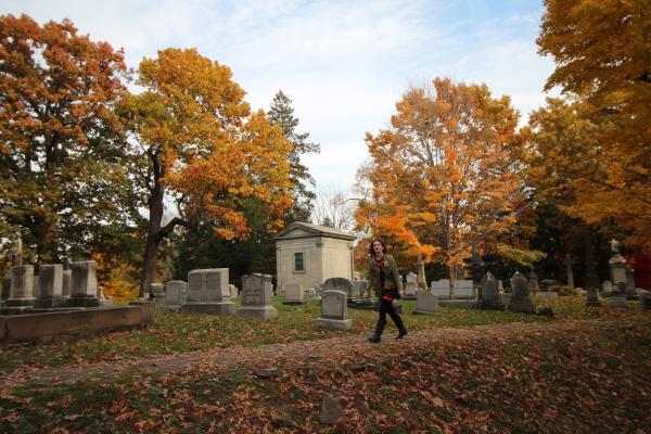 woman walking through Mount Hope cemetery in Rochester, NY