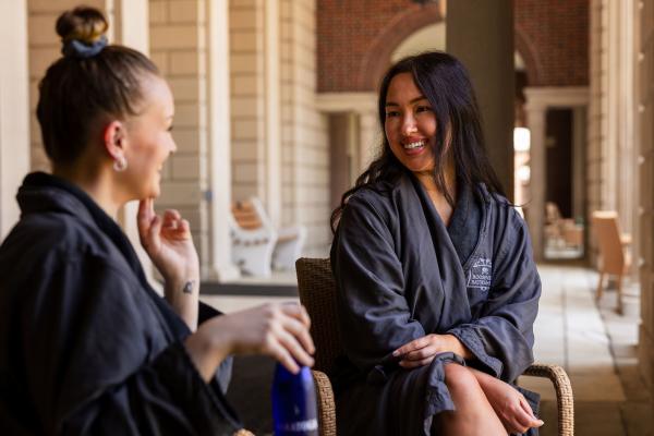 two women in bathrobes sitting outside roosevelt baths
