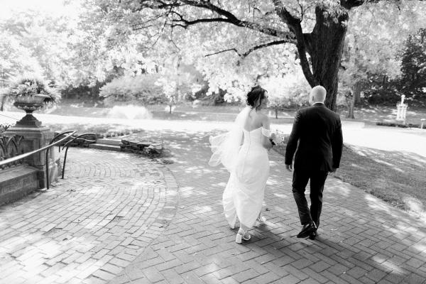 bride and groom walking in park, black & white