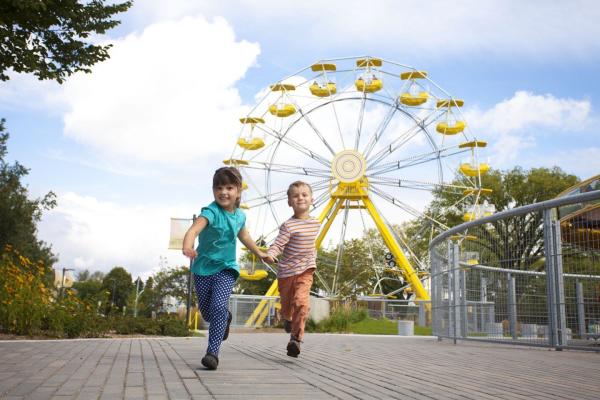 Children running with Ferris wheel in the background