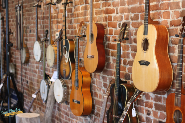 Guitars hanging on a brick wall at Driftwood Music in St. Charles, MO