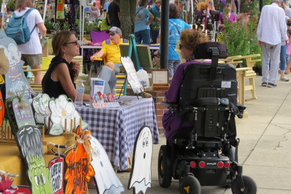person in wheelchair browsing stall at St Tammany Community market
