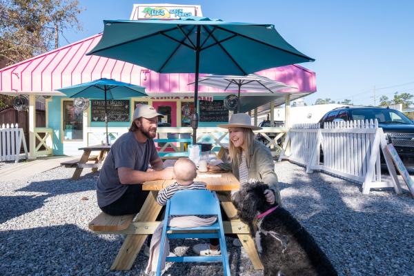 Couple with baby and dog dining at the beach