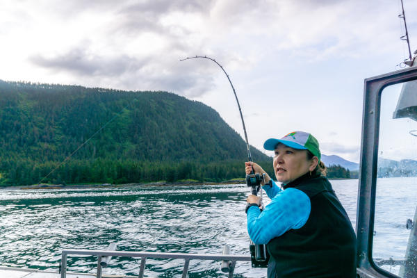 a woman on a charter boat holding a fishing rod