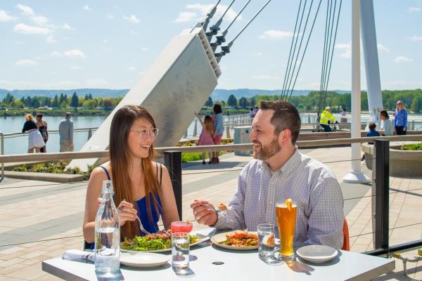 Man and woman enjoy waterfront dining at WildFin restaurant