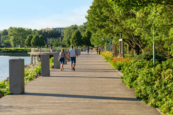 Couples enjoy a summer walk down the waterfront boardwalk in Burlington VT