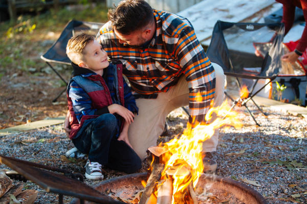 Father and son next to a camp fire