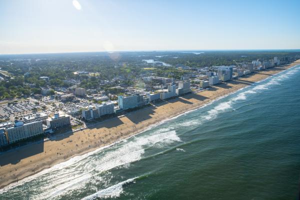 Aerial perspective of beach shoreline with hotels and businesses in distance