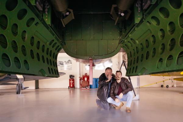 Two men underneath an airplane display at an aviation museum