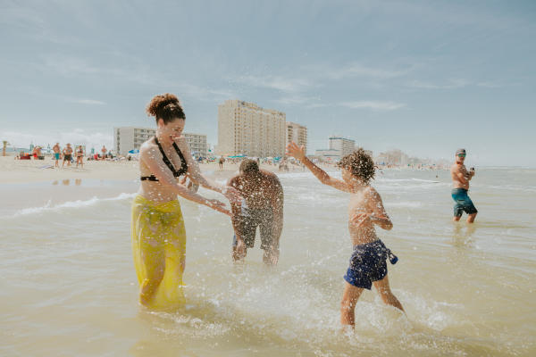 Family splashing along shoreline on warm summer day