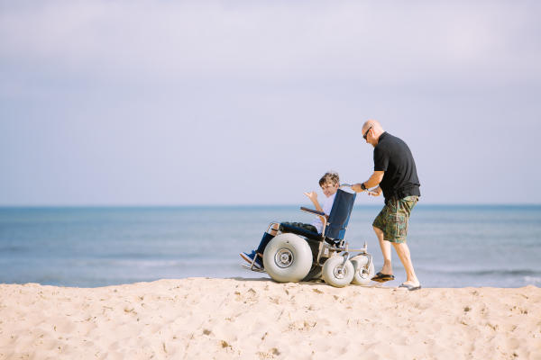 A child being pushed in a beach wheelchair in Virginia Beach.jpg
