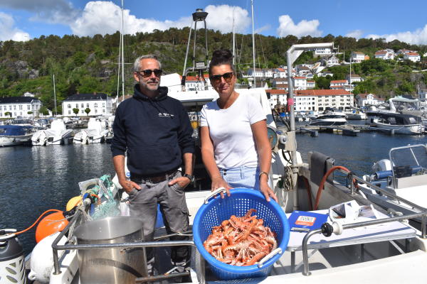 to mennesker på båt med en bøtte sjøkreps