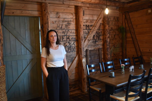 Dame foran rustikk vegg i restaurant