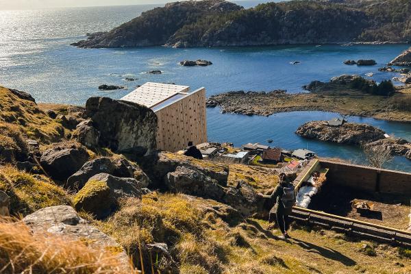 hytte på en ås med havet i bakgrunnen