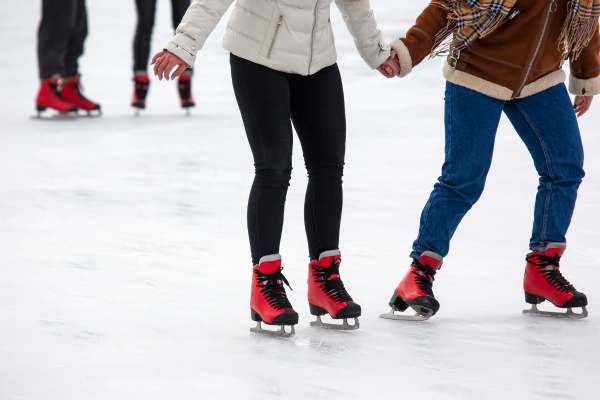 Couple holding hands ice skating