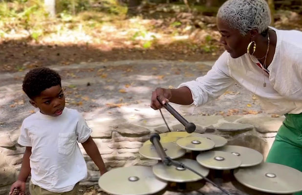 Cynthia and son Kai playing an instrument at the Music Circle station along on the Autism Nature Trail in Letchworth State Park
