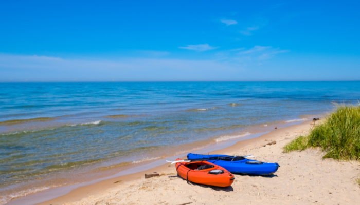 and orange and blue kayak are banked on the shoreline of lake michigan at Meinert Parkin muskegon michigan