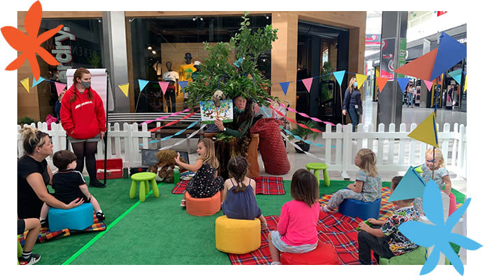 Children siting listening to a story in the Quadrant shopping centre.