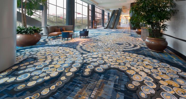Photo of concourse in the downtown Houston Hilton hotel with large windows, daylight and swirling carpet pattern