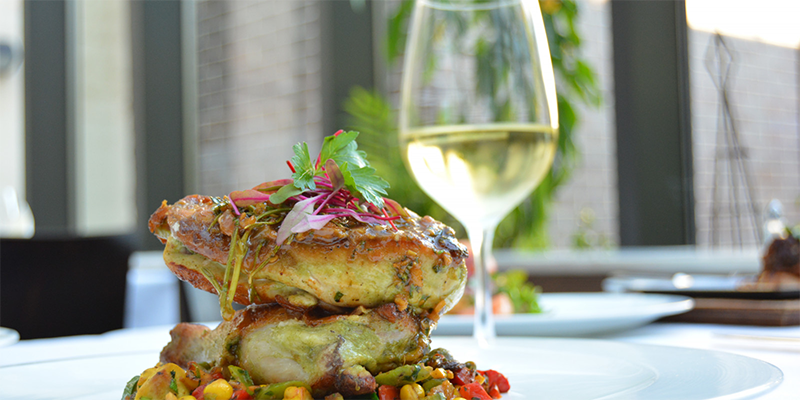 Porterhouse Restaurant gourmet roasted chicken dish with a glass of wine