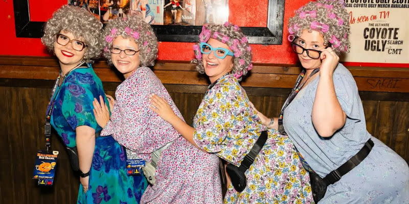 Four women are dressed as older women at a Halloween Bar Crawl
