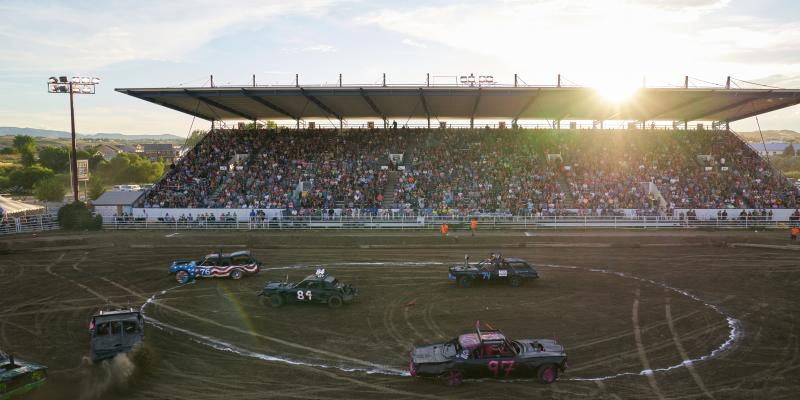 A crowd watching cars race at the Wyoming State Fair demolition derby.