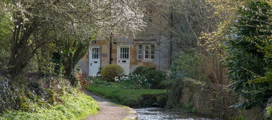 Blockley in the Summer- view of some small terraced houses tucked around the river