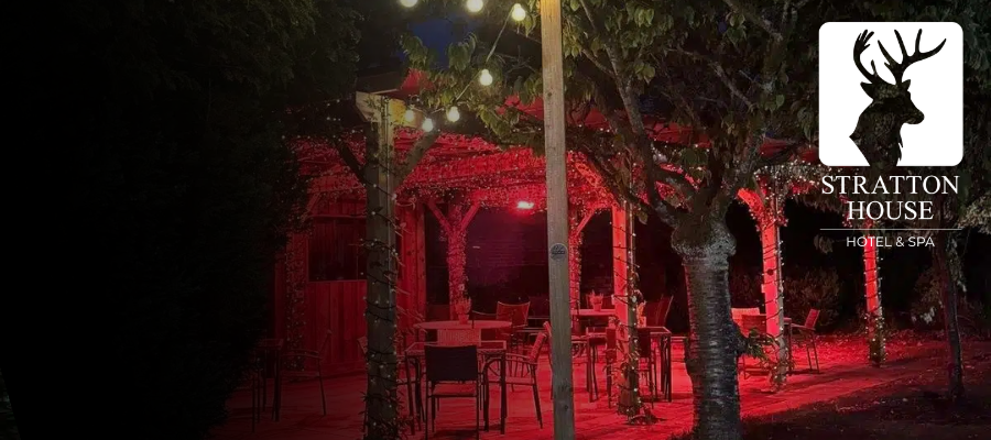 The pergola at Stratton House Hotel in the Cotswolds lit up with red lights