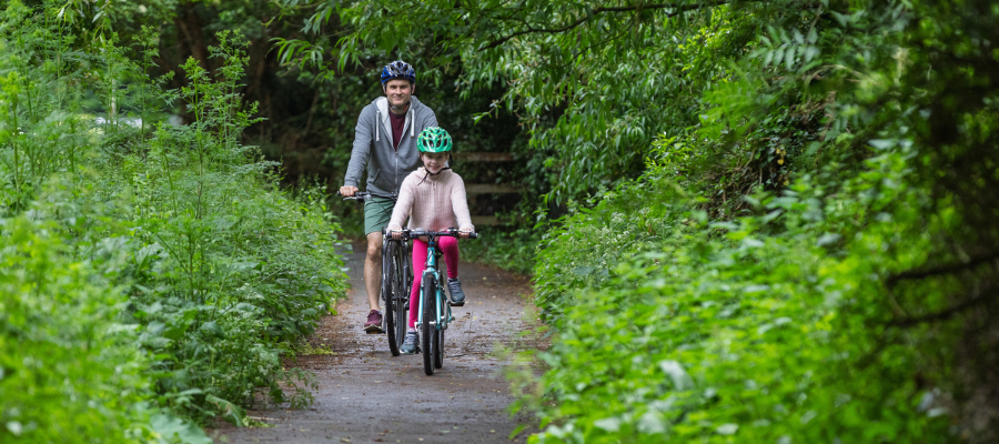 father and daughter on bikes in countryside