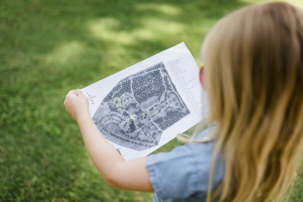 A young girl viewing a map of Fayetteville's Cape Fear Botanical Gardens