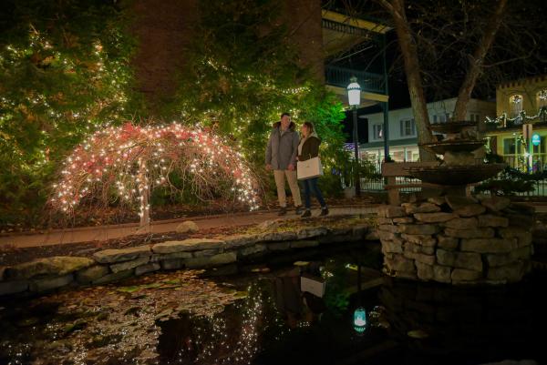 Couple walking by Christmas lights