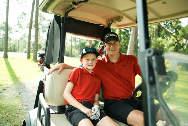 father and son riding golf cart