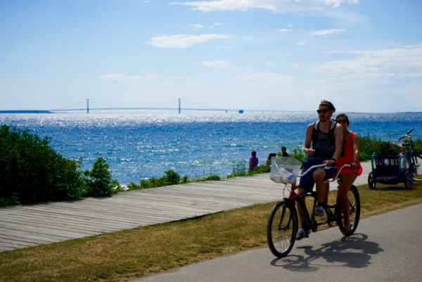 Couple Biking by Lake – Mackinac Island Tourism Bureau
