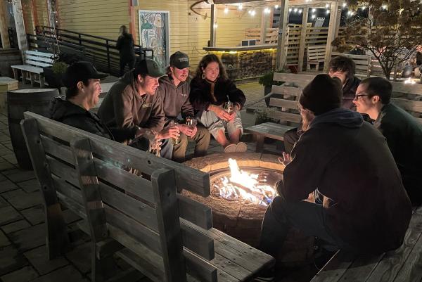 A group of friends sitting around the fire pit at Blackrocks Brewery