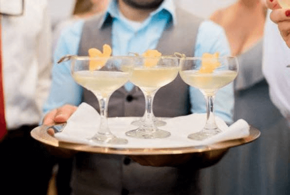 Waiter serving cocktails on a tray, ideal for romantic weekend drinks in Cheyenne for Valentine's Day.