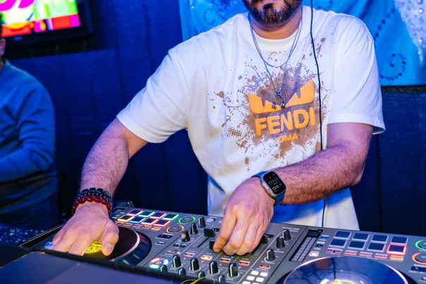 Man working a DJ table in a black light room
