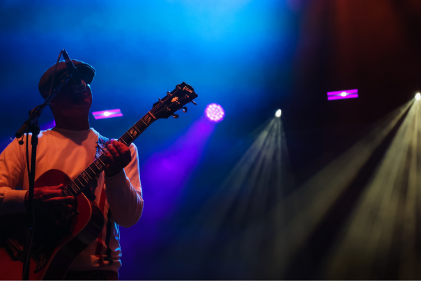 man with a guitar in stage shadow