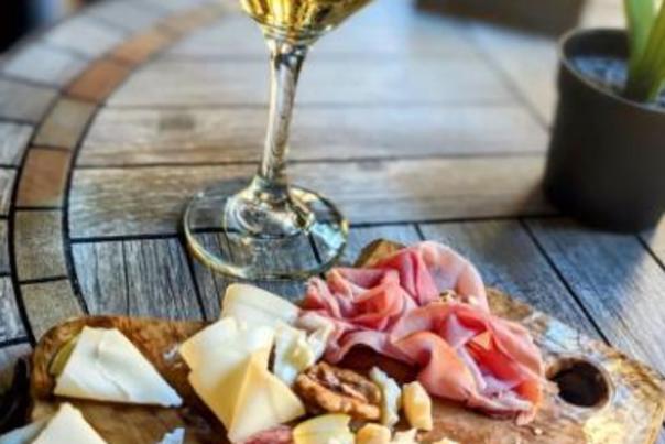 a glass of wine and a cheese board