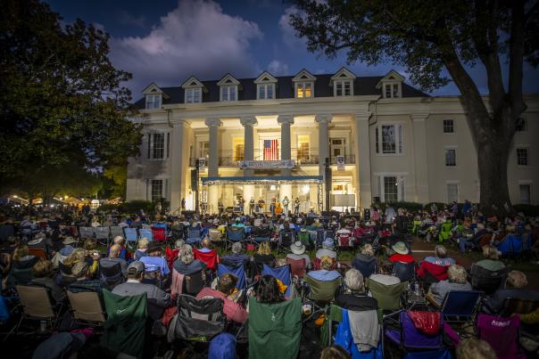 Hundreds of attendees seated in front of Founders Hall on the campus of Athens State University