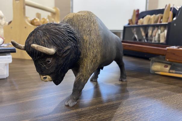 Handcarved wooden bison sets on a table.