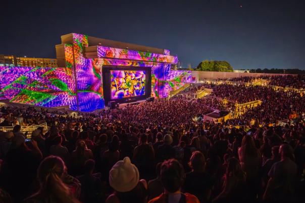 Pic of the Orion Amphitheater during a concert with a crowd of people. Colorful lights