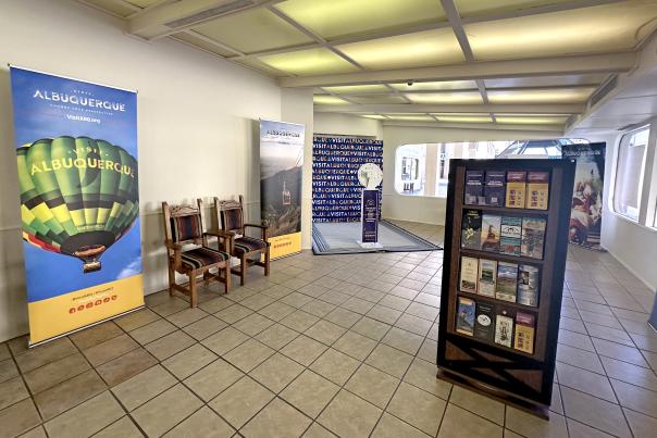 The interior of the Convention Welcome Center, featuring chairs, a brochure rack, banners, and a photo station.