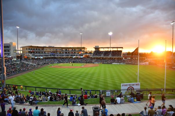 Isotopes Park from the berm area with the sun setting in the background.