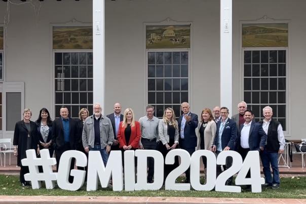 The Visit Albuquerque Board stands behind foam letters that spell #GMID2024