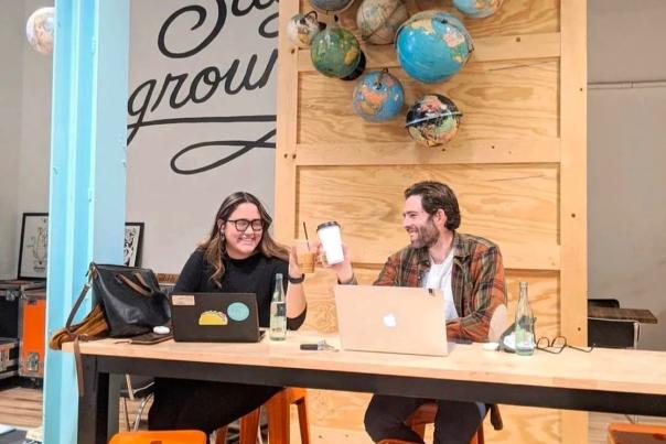 Two people sit at a table in Humble coffee working on laptops