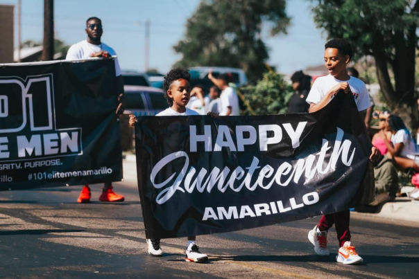 Photo of two boys holding "Happy Juneteenth Amarillo" Banner at Bones Hooks Park